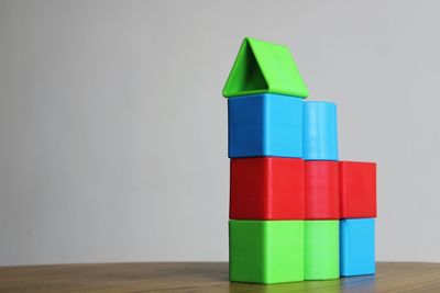 Business growth chart made of stack of multi colored toy blocks on table against white background 