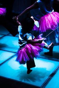 Rear view of woman dancing at night