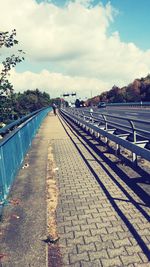 Empty road in city against sky