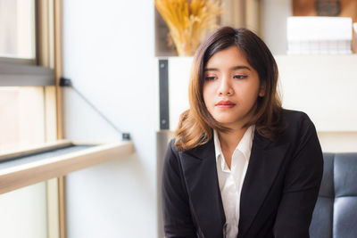 Businesswoman looking away while sitting on couch