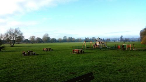 People on grassy field against sky