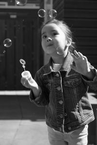 Girl looking at camera while standing against blurred background