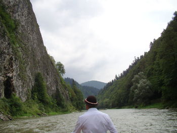 Rear view of man looking at mountain against sky