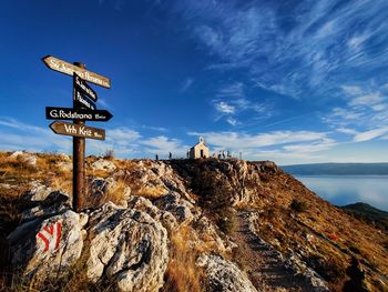 Information sign on rock against sky