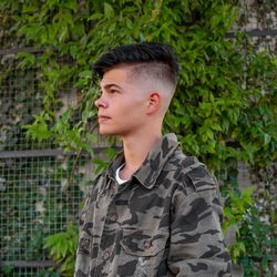 Boy looking away while standing outdoors