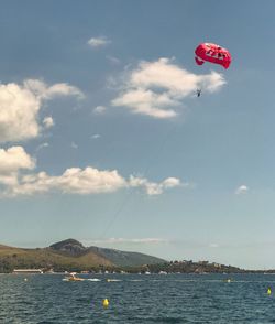 Low angle view of paragliding over sea against sky