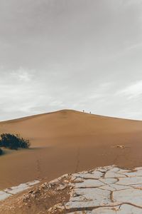 View of desert against cloudy sky