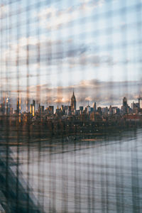 Digital composite image of buildings against cloudy sky