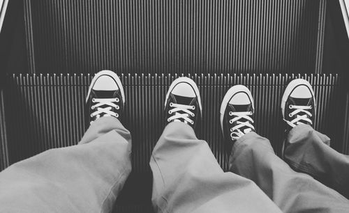 Low section of people standing on escalator