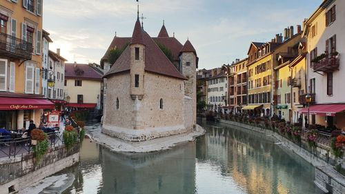 Canal amidst buildings in town against sky