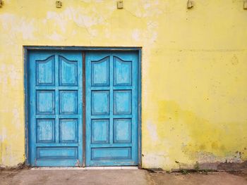 Wall with blue door and yellow colour