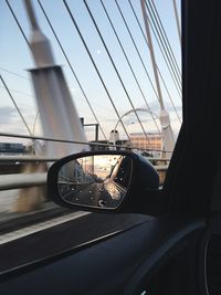 Cars moving on bridge against sky seen through car window