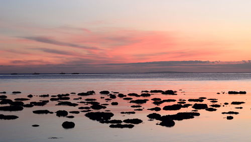 Scenic view of sea against romantic sky at sunset