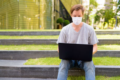 Full length of man using mobile phone outdoors