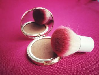 Close-up of make-up brush on blush on table