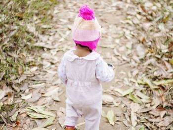 Rear view of baby girl walking on field