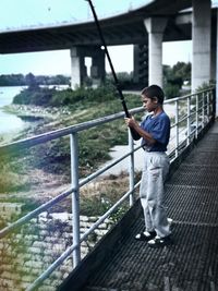 Full length of man standing on railing