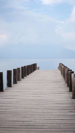 Wooden pier over sea against sky