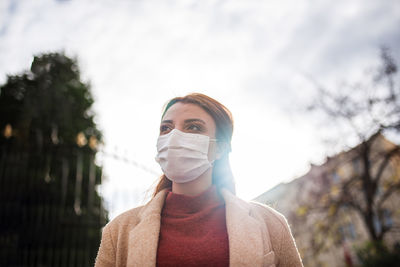 Portrait of woman standing against sky