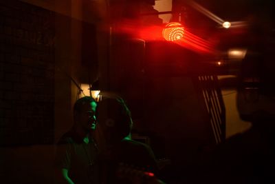 People sitting in illuminated lights at night