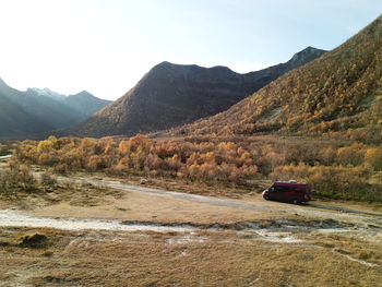 Camping car on road by mountains against sky