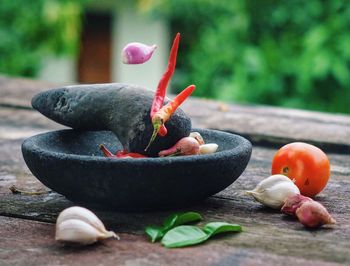 Close-up of molar and pestle with food ingredients on table