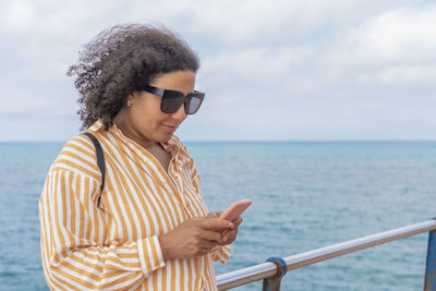 Smiling woman with glasses using her phone