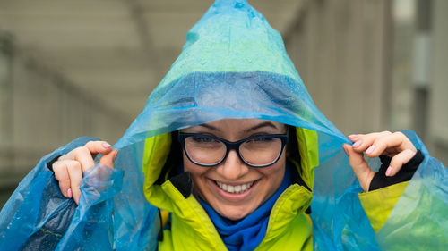 Portrait of smiling woman wearing raincoat outdoors