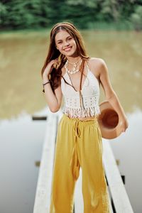 Portrait of smiling young woman standing at beach