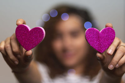 Close-up of woman holding heart shaped hand