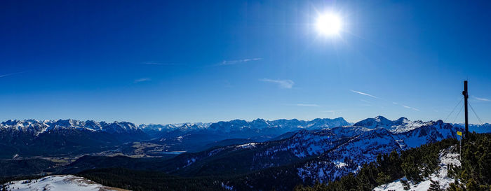 Scenic view of snowcapped mountains against blue sky