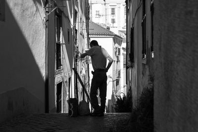 Man standing in alley amidst houses