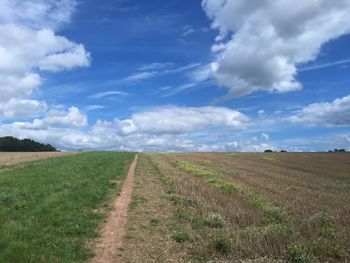 Scenic view of grassy field against cloudy sky