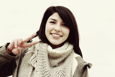 Portrait of smiling young woman against white background