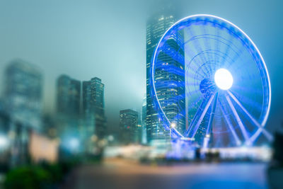 Low angle view of illuminated ferris wheel against sky