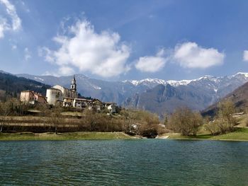 Scenic view of lake by buildings against sky