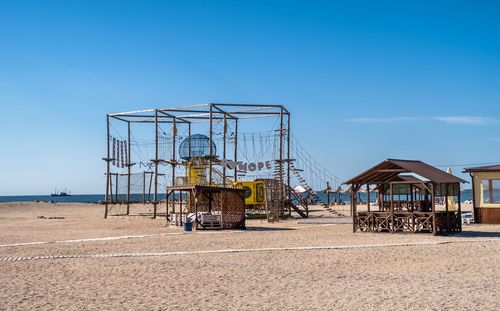 Lifeguard hut on beach against clear blue sky