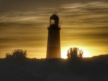 Lighthouse against sky during sunset