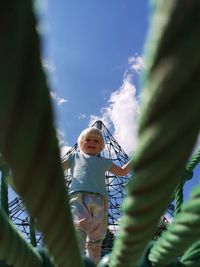 Low angle view of girl on plant against sky
