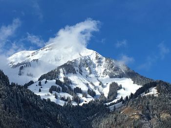 Panoramic view of snowcapped mountains against blue sky