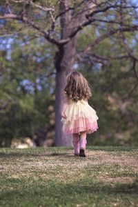 Rear view of woman standing on field