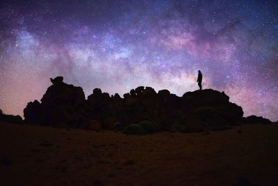 Low angle view of silhouette rocks against sky at night