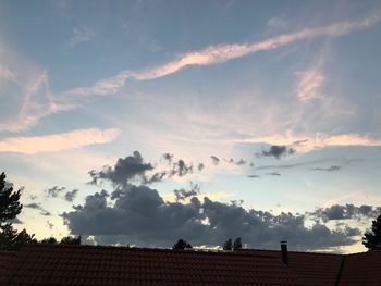 Low angle view of house roof against sky during sunset