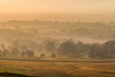 Scenic view of field against sky at foggy weather