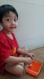 Portrait of cute smiling boy sitting on floor