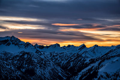Scenic view of snowcapped mountains against sky during sunset