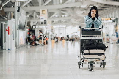 Full length of woman sitting at airport