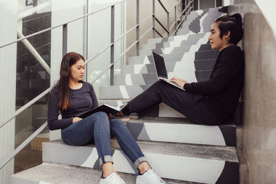 Young woman sitting on staircase