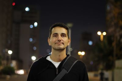 Portrait of smiling man in city at night