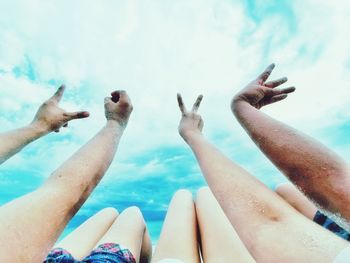 Low section of people by sea against sky